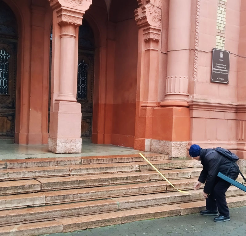 Measuring the stairs in front of the facade